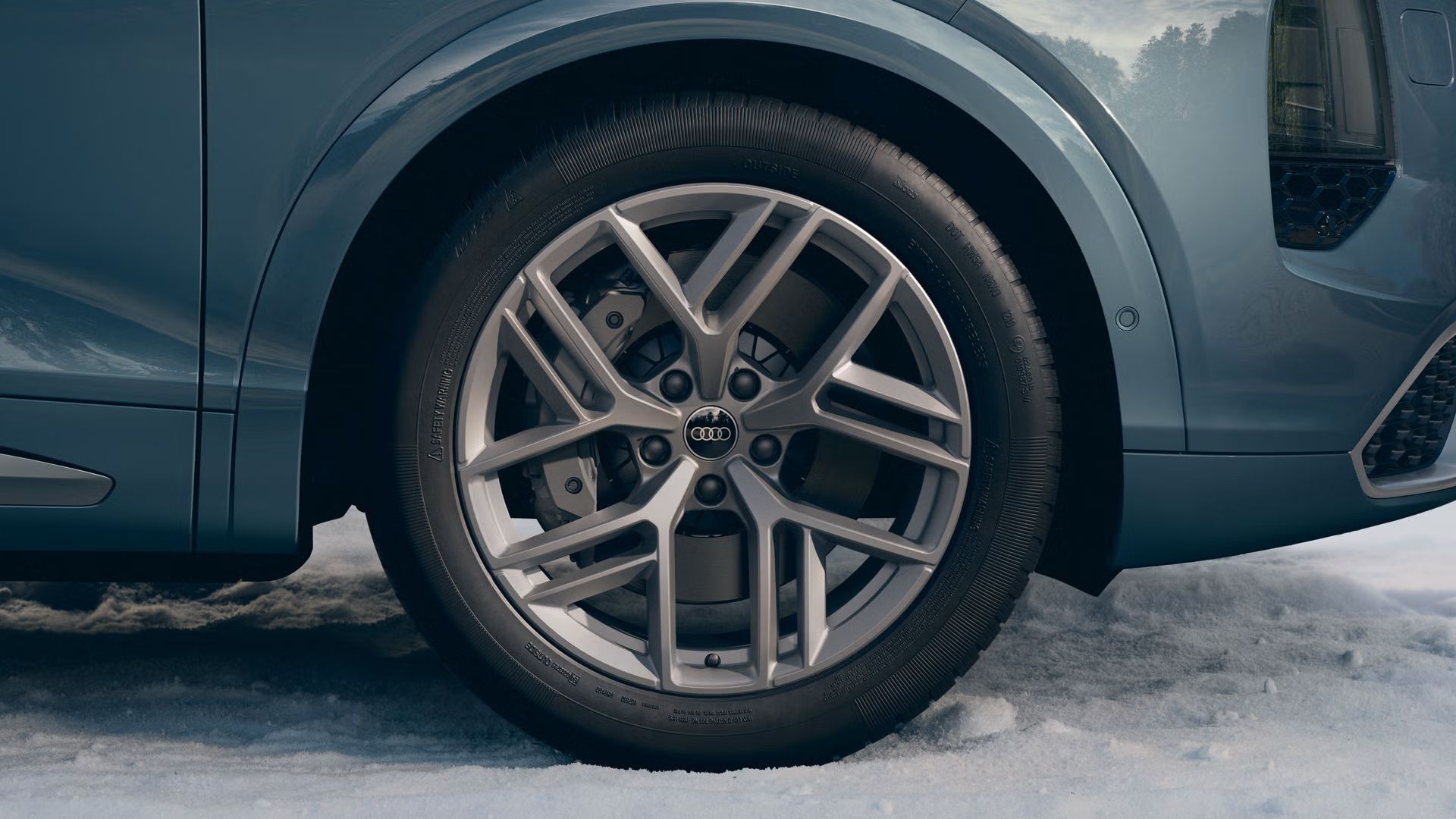 Nahaufnahme eines Audi-Rads mit 21 Zoll Leichtmetallfelgen im 5-Speichen-Tripod-Design in Platingrau.