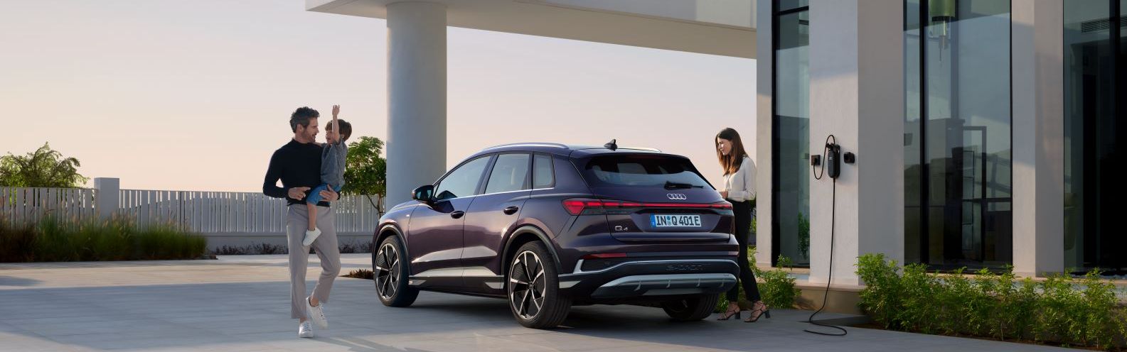 Eine Familie parkt mit ihrem Audi Q4 an einer Ladestation.