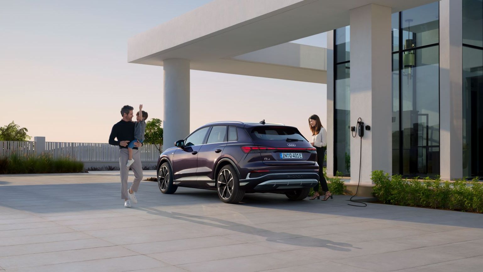 Eine Familie parkt mit ihrem Audi Q4 an einer Ladestation.