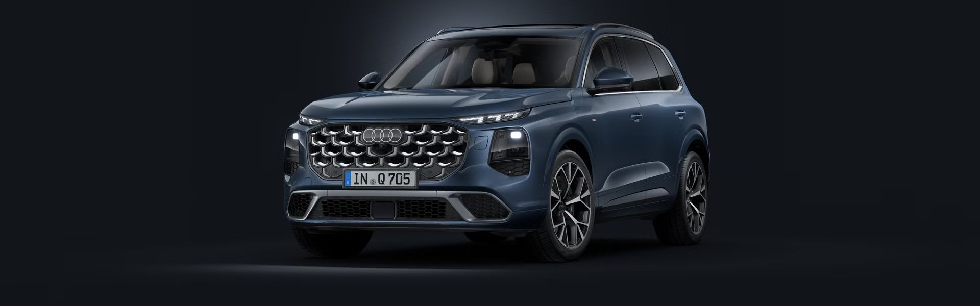 Schräge Frontansicht des Audi Q7 SUV auf dunklem Hintergrund.