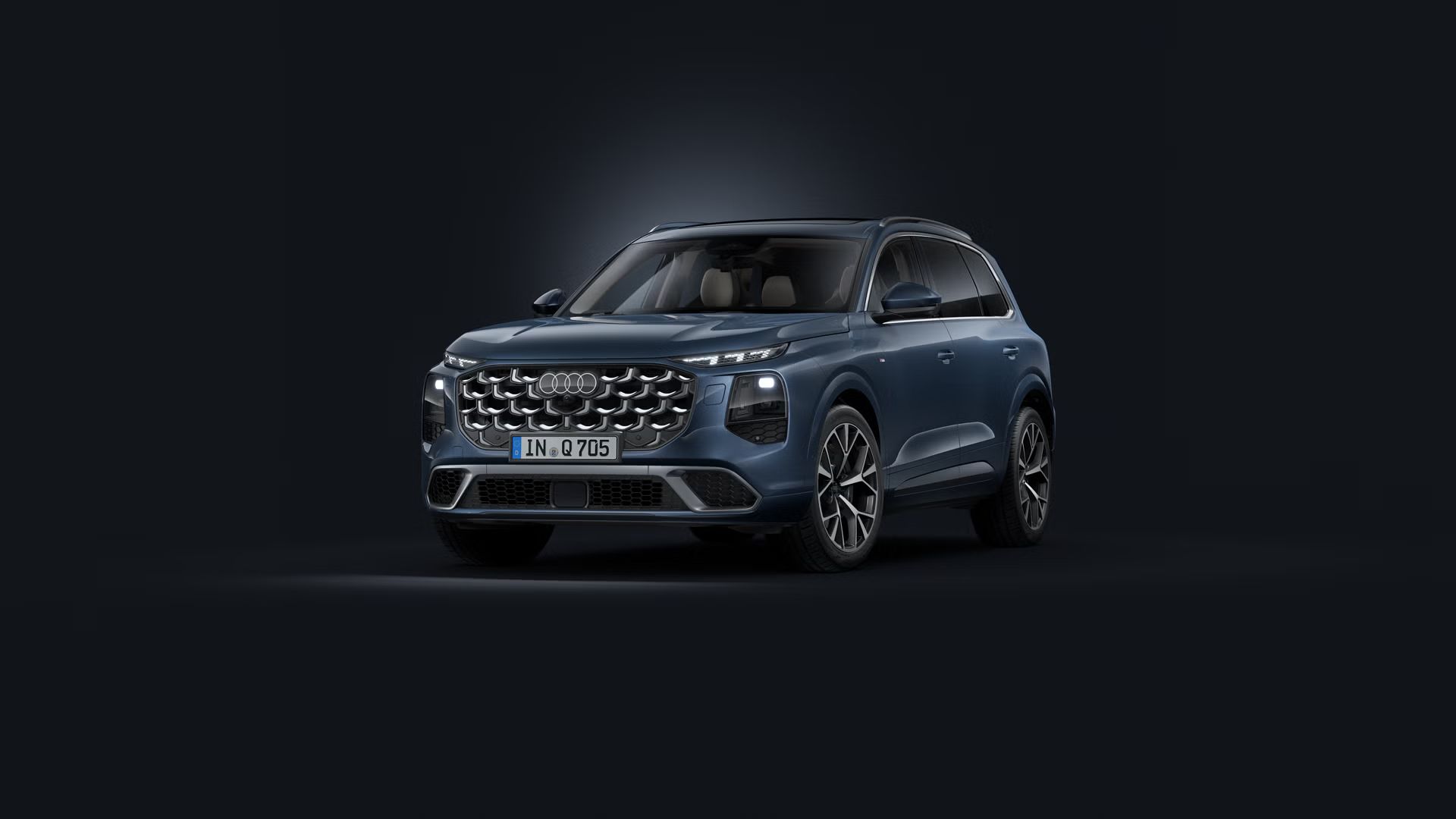 Schräge Frontansicht des Audi Q7 SUV auf dunklem Hintergrund.